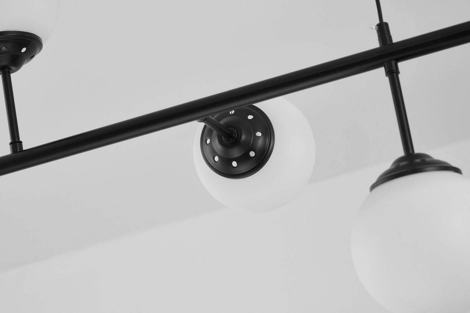 lampa fino w6 od lampit czarna z białą kulą i metalowym ramieniem uchwycona z bliska z widocznym mocowaniem
