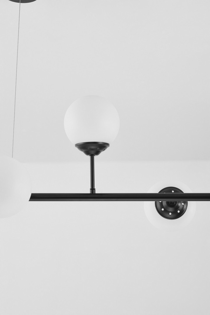 lampa wisząca czarna fino w6 od lampit z białą szklaną kulą zawieszoną na metalowym ramieniu widoczna z bliska