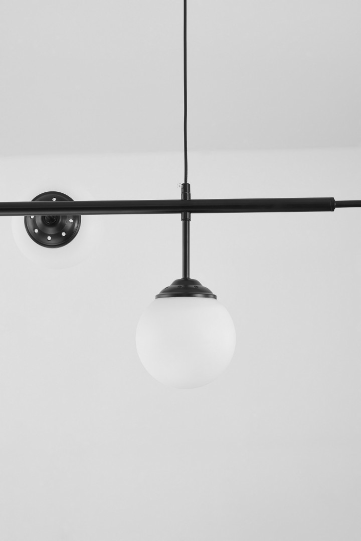 lampa sufitowa czarna fino w6 od lampit z białą kulą i metalowym mocowaniem pokazana zbliżeniowo na tle sufitu