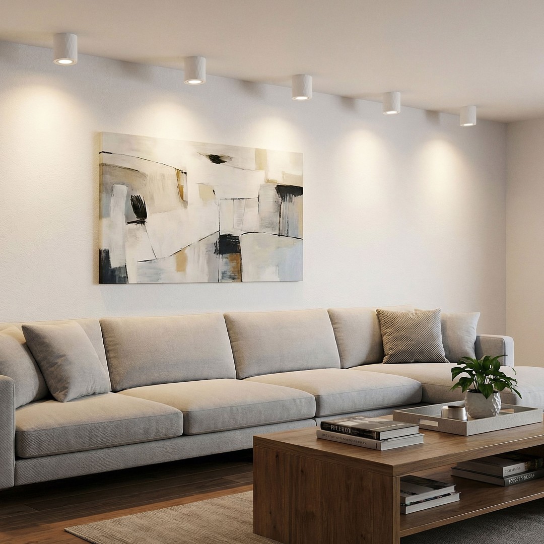 elegancka aranżacja salonu z białymi lampami sufitowymi LED oświetlającymi ścianę za kanapą