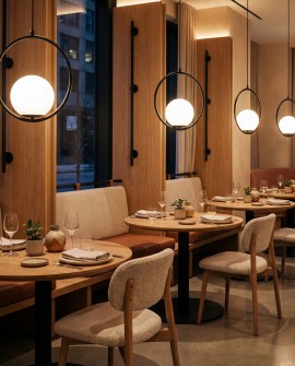 lampa wisząca czarna z centralną kulą i cienką obręczą akcentowe oświetlenie przy stolikach restauracyjnych