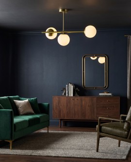 Złota lampa sufitowa LEDO W3 Long Lampit z białymi kulami w eleganckim salonie z ciemną ścianą