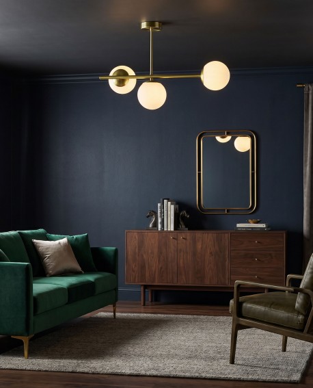 Złota lampa sufitowa LEDO W3 Long Lampit z białymi kulami w eleganckim salonie z ciemną ścianą