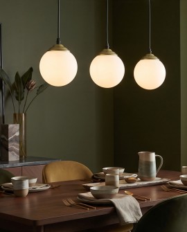 Nowoczesna złota lampa z mlecznymi szklanymi kloszami zawieszona nad stołemNowoczesna złota lampa z mlecznymi szklanymi kloszami