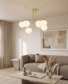Złota oprawa lampy centralnie zamontowana w minimalistycznym salonie