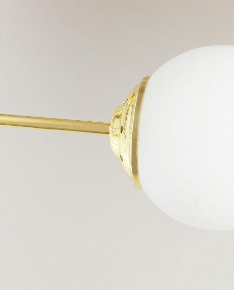 Fragment lampy wiszącej z mlecznym kloszem i metalową częścią