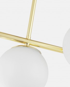 Zbliżenie na metaliczny stelaż w kolorze klasycznego złota i klosz lampy wiszącej