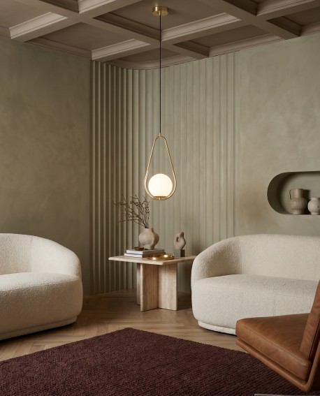 Nowoczesna lampa wisząca Lampit VERO 1C w złotym kolorze zawieszona w stylowym salonie z dwoma sofami