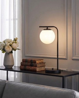 Czarna lampa biurkowa z białą kulą pasuje do eleganckiego wystroju salonu