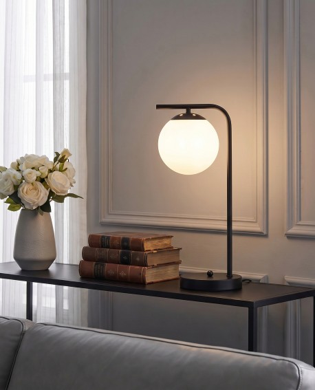 Czarna lampa biurkowa z białą kulą pasuje do eleganckiego wystroju salonu