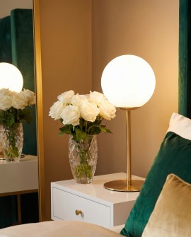 Biała kula na złotej podstawie FREDICA Lumina Deco na stoliku nocnym w sypialni