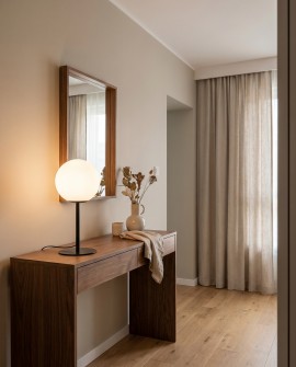 Lampa stołowa Fredica Slim biała kula na czarnym stelażu przy lustrze w korytarzu