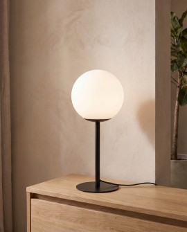 Czarna metalowa lampa z białą kulą ozdabia pokój dzienny