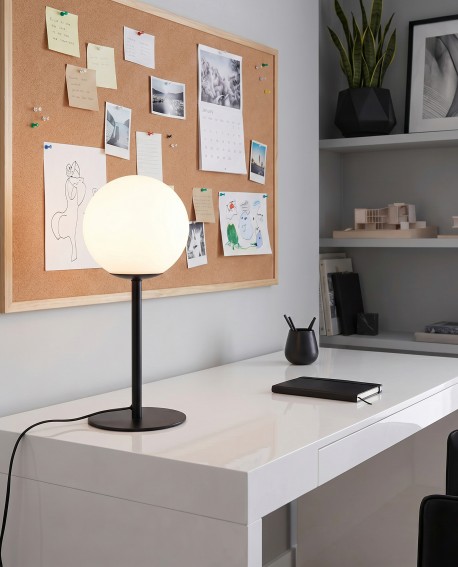 Czarna lampa stołowa Fredica Slim z kulistym białym kloszem na biurku w domowym biurze