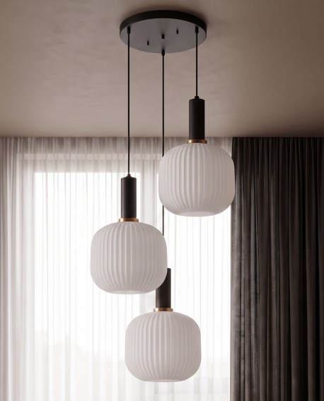 Loftowa lampa wisząca z trzema mlecznymi kloszami zawieszona w salonie na czarnej podsufitce
