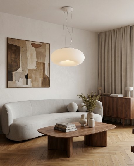 Nowoczesna lampa wisząca BIANTE oświetla salon z okrągłym stolikiem i sofą